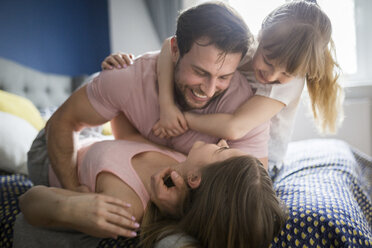 Glückliche Familie im Bett liegend, kuschelnd - AWF00013