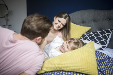 Happy family lying in bed, cuddling - AWF00014