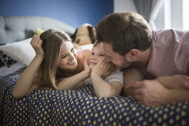 Happy family lying in bed, cuddling - AWF00015