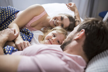 Happy family lying in bed, cuddling - AWF00034