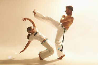 Mid adult couple practising capoeira - CUF25930