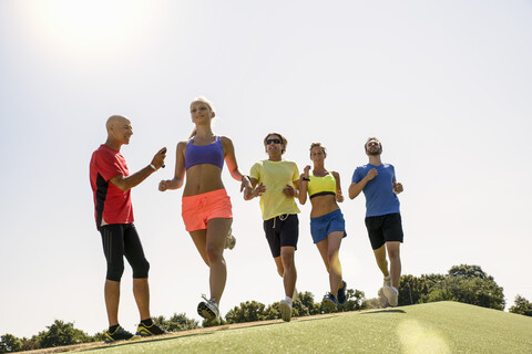 Zeitmessung einer Gruppe von Läufern durch einen Trainer, lizenzfreies Stockfoto
