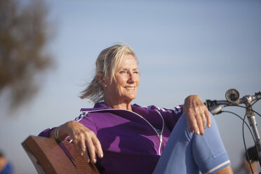Ältere Frau genießt den Meerblick auf einer Bank - CUF26029