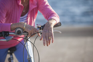 Ältere Frau auf dem Fahrrad am Strand - CUF26031