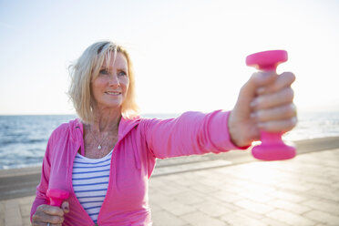 Ältere Frau beim Training mit Gewichten am Strand - CUF26037
