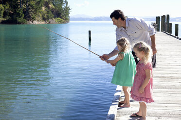 Älterer Mann und zwei junge Mädchen angeln vom Pier, Neuseeland - CUF26045