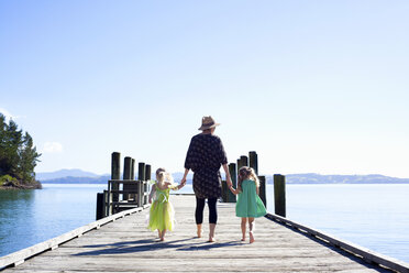 Mittlere erwachsene Frau und Töchter spazieren am Pier, Neuseeland - CUF26052