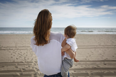 Rear view of mid adult woman and toddler daughter looking out to sea, Castelldefels, Catalonia, Spain - CUF26059
