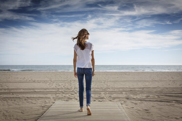 Rückansicht einer mittleren erwachsenen Frau, die am Strand spazieren geht, Castelldefels, Katalonien, Spanien - CUF26060