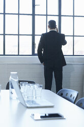 Rear view of business man chatting on smartphone in conference room - CUF26154