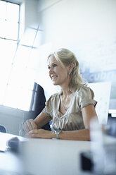 Businesswoman at conference table in office meeting - CUF26171