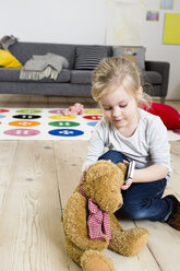 Mädchen spielt mit Teddybär zu Hause - CUF26224