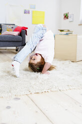 Girl trying to do headstand at home - CUF26227