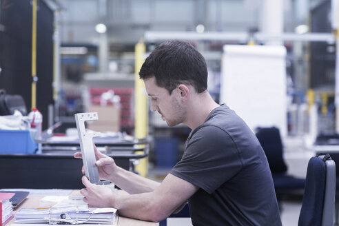 Ingenieur bei der Arbeit an einer Metallschiene in einer Maschinenfabrik - CUF26290