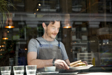 Waiter preparing order at cafe window - CUF26335