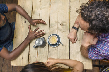 Draufsicht auf Freunde, die sich am Kaffeehaustisch unterhalten - CUF26350