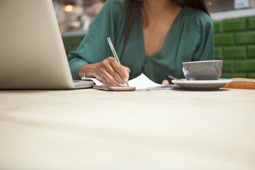 Cropped shot of woman doing paperwork at cafe table - CUF26364