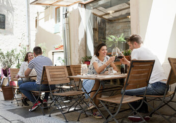 Junge Paare stoßen in einem Restaurant auf dem Bürgersteig mit Wein an, Split, Dalmatien, Kroatien - CUF26373