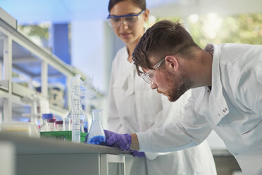 Scientist examining conical flask - CUF26377