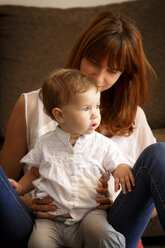 Mid adult woman playing with toddler daughter in sitting room - CUF26489