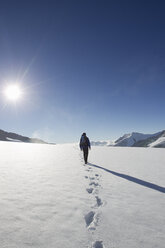 Rückansicht eines männlichen Wanderers und Fußspuren im Schnee, Jungfrauchjoch, Grindelwald, Schweiz - CUF26528