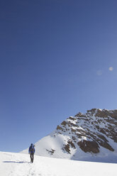 Rückansicht eines Mannes, der durch eine schneebedeckte Landschaft wandert, Jungfrauchjoch, Grindelwald, Schweiz - CUF26531