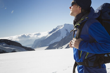 Male hiker in snow covered mountain landscape, Jungfrauchjoch, Grindelwald, Switzerland - CUF26541