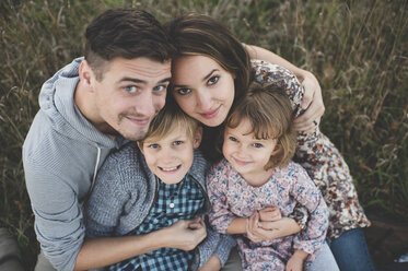 Overhead portrait of young couple with son and daughter in field - CUF26597