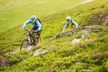 Junge Mountainbikerinnen und Mountainbiker fahren auf einer Bergstrecke - CUF26670