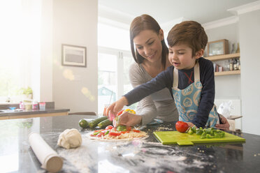 Mutter und Sohn bereiten gemeinsam in der Küche eine Pizza zu - CUF26914