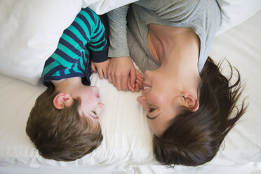 Mother and son relaxing together in bed, overhead view - CUF26918