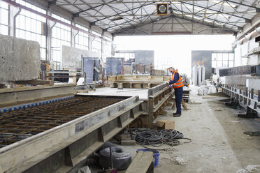 Factory worker on production line in concrete reinforcement factory - CUF26987