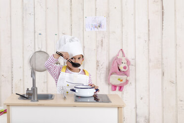 Porträt eines kleinen Mädchens, das mit einer Spielzeugküche spielt - DRF01739