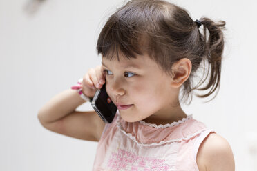 Portrait of smiling little girl on the phone - DRF01742