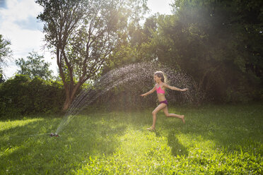 Kleines Mädchen hat Spaß mit Rasensprenger im Garten - LVF07058
