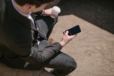 Blick über die Schulter eines jungen Geschäftsmannes beim Lesen von Smartphone-Texten - CUF27111