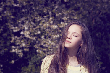 Portrait of girl with eyes closed in front of foliage - CUF27138