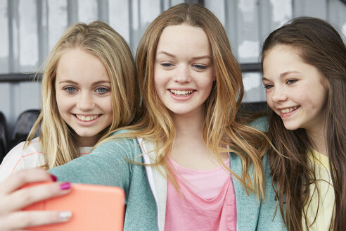 Drei Mädchen posieren für ein Smartphone-Selfie im Tierheim - CUF27143