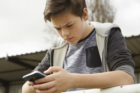 Ängstlicher Teenager liest Smartphone-SMS - CUF27147