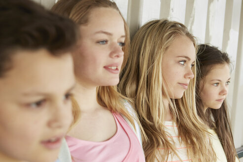 Drei Mädchen und ein Junge schauen aus einem Unterstand heraus - CUF27149