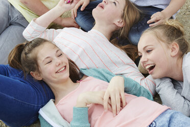 Cropped view of five boys and girls lying on ground - CUF27155