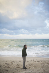 Mid adult man on stormy beach, Sorso, Sassari, Sardinia, Italy - CUF27212