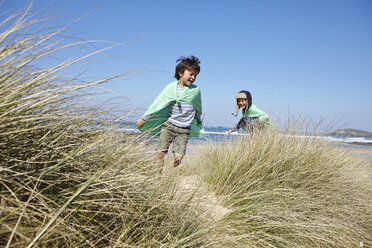 Zwei Jungen in Kostümen, die am Strand spielen - CUF27228