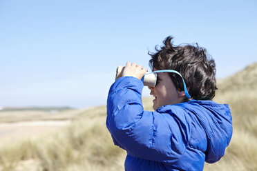 Kleiner Junge am Strand, der durch ein vorgetäuschtes Fernglas schaut - CUF27231