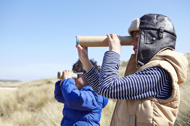 Zwei kleine Jungen am Strand, die durch ein vorgetäuschtes Fernglas schauen - CUF27232