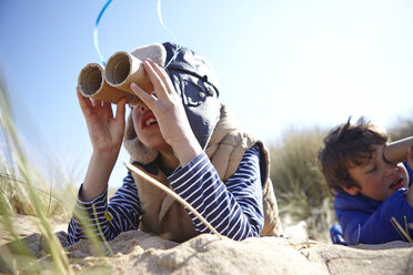 Zwei kleine Jungen am Strand, die durch ein vorgetäuschtes Fernglas schauen - CUF27236