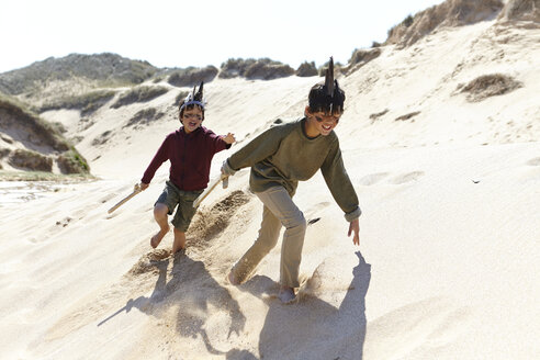 Two boys, wearing fancy dress, playing on sand - CUF27265