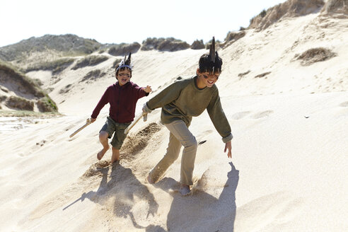 Zwei Jungen in Kostümen, die im Sand spielen - CUF27265