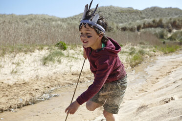 Junger Junge, der ein Kostüm trägt, läuft auf Sand - CUF27268