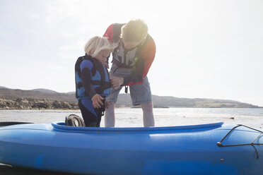 Vater hilft Sohn beim Anpassen der Schwimmweste im Kanu, Loch Eishort, Isle of Skye, Hebriden, Schottland - CUF27286